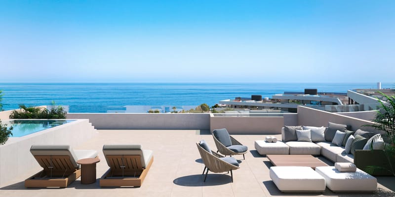 A new-build apartment building on the Costa del Sol seen from the side, its terraces looking out over the beach